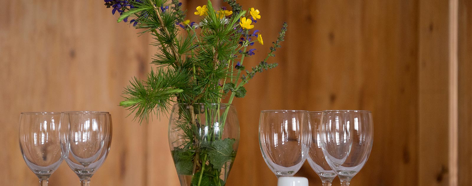 Tischdekoration mit Blumen und Weingläser auf einem Tisch im Briol